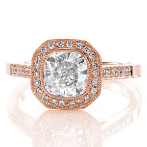 This beautiful halo ring features a 1.20 carat cushion cut center in a full bezel setting. There is micro pavé detailing on the halo, band, and even under the setting of the center diamond! This touch really adds to this splendid design. The look is completed with fine, milgrain on all the edges. 