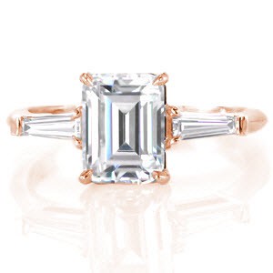 Charlotte classic custom engagement ring on a slim polished band with an emerald cut diamond center bordered on either side by a tapering banquette diamond.