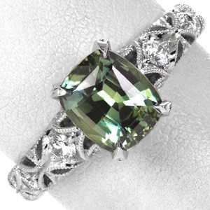 Cushion cut green sapphire engagement rings in Austin are the perfect choice for any nature lover. This gorgeous star-burst design is set with micro pave diamonds. 