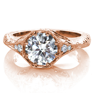 This eye-catching design showcases a 1.5 carat round brilliant cut center diamond in a unique octagonal setting. Side stones taper into a an elegant band adorned with two styles of hand-done engraving. Beautiful hand formed filigree curls, milgrain detail, and clusters of surprise diamonds complete this lovely ring.
